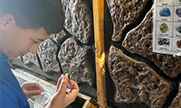  A boy looks closely at a gem found during a field trip mining adventure.